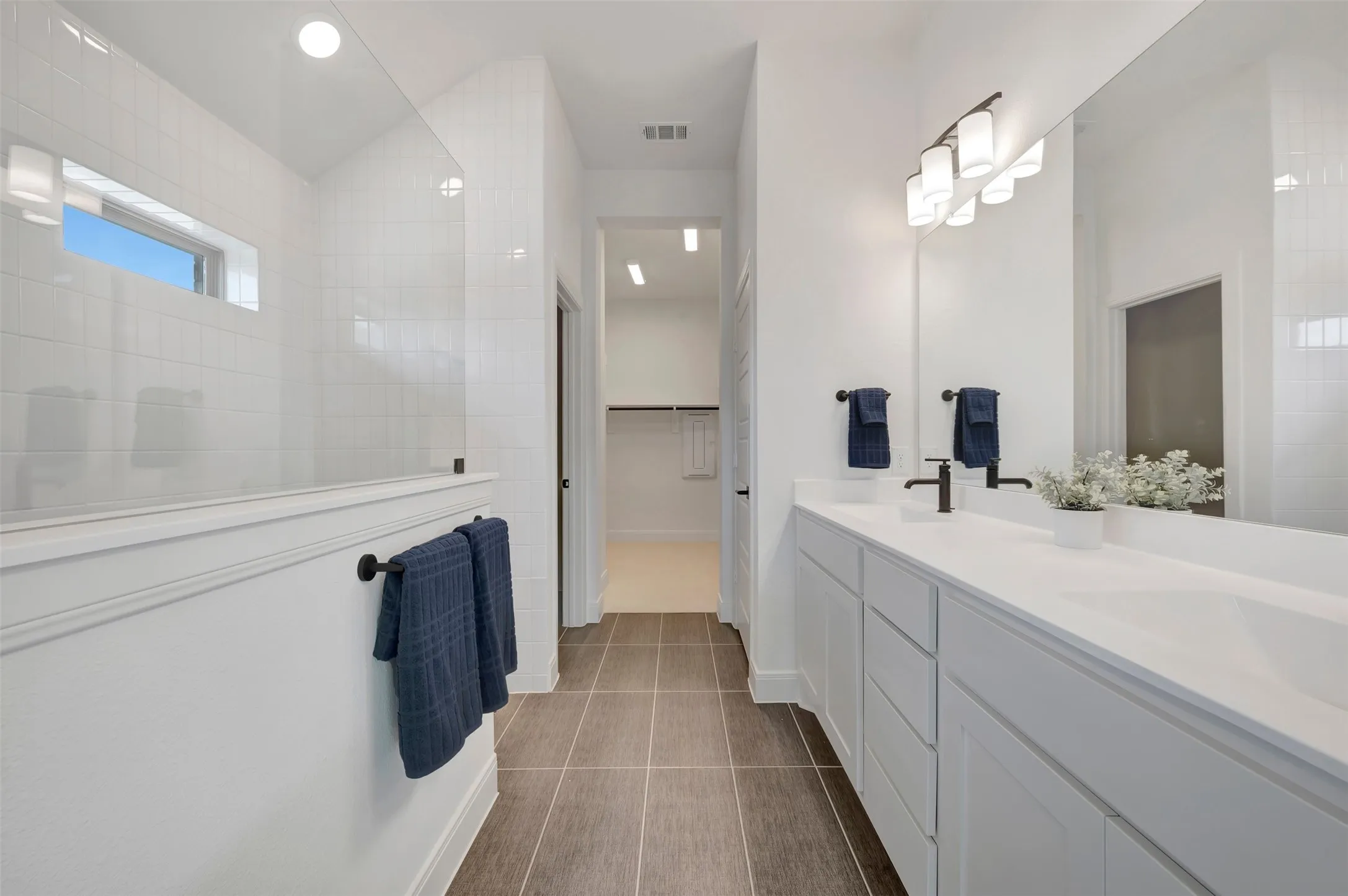 Modern bathroom featuring a dual vanity with undermount sinks, white countertops, and matte black fixtures