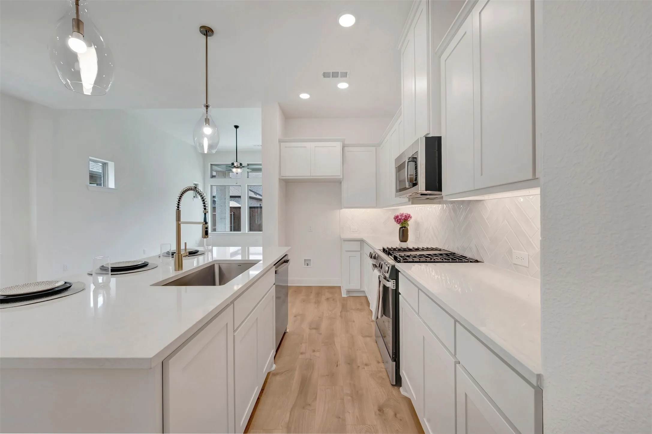 Contemporary kitchen featuring an expansive island with an undermount sink and gooseneck faucet