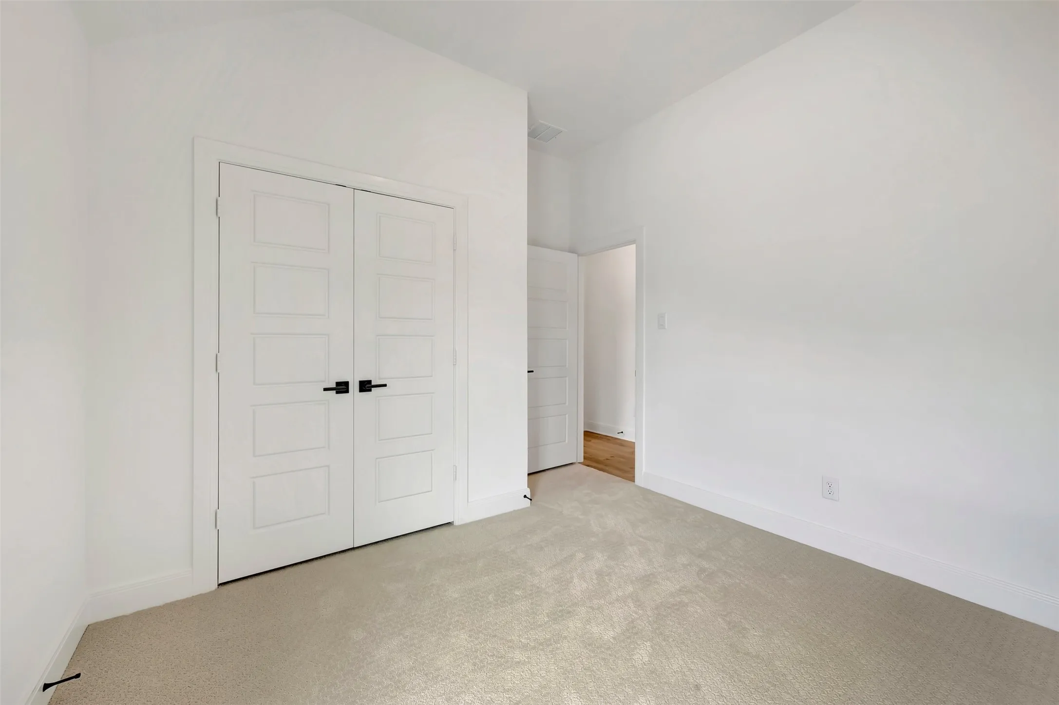 Room featuring neutral carpeting, crisp white walls, and bright white trim