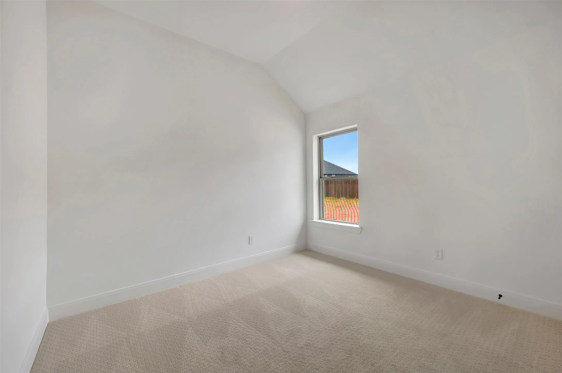 Room featuring a single-pane window, vaulted ceiling, neutral wall color, and carpeted flooring