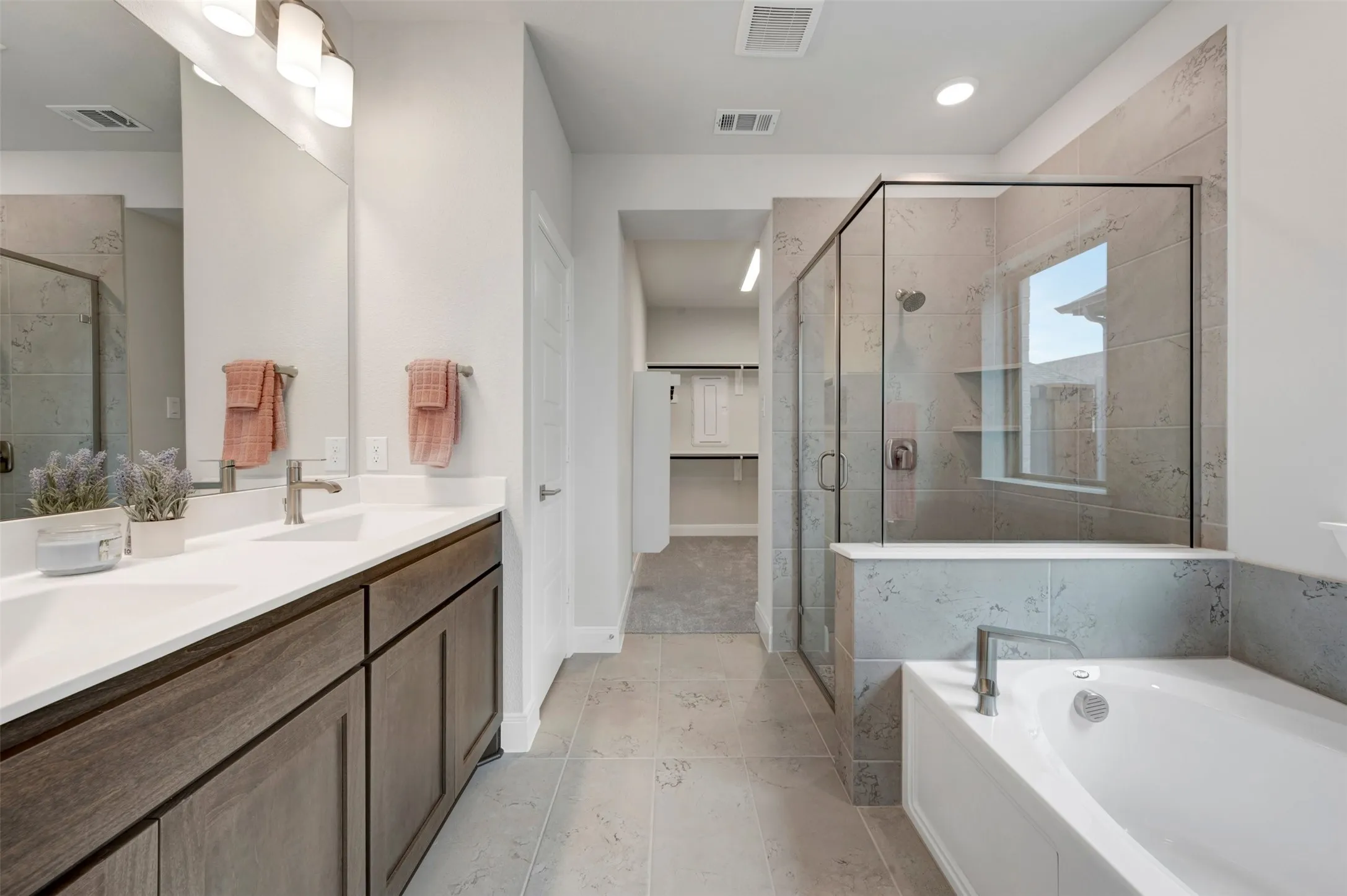 Double vanity with white countertop and wood-finish cabinetry