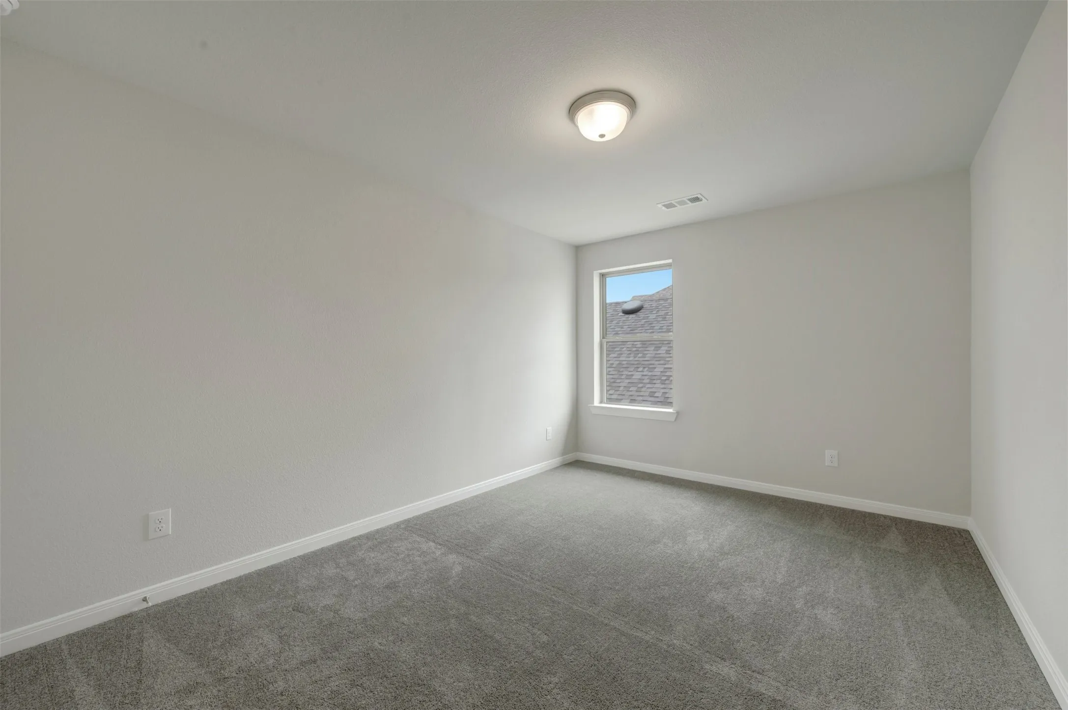 Room featuring light gray walls, gray carpet flooring, white baseboards, and a single window with white trim