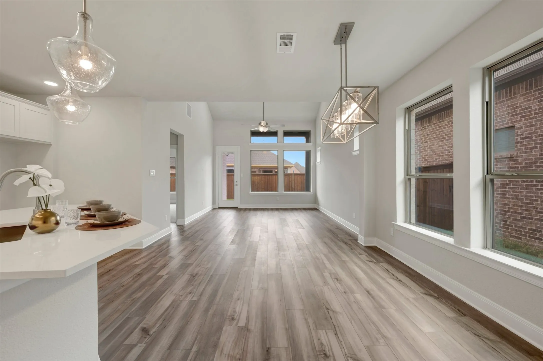 Open concept room featuring wood-finish flooring, white walls, and multiple windows