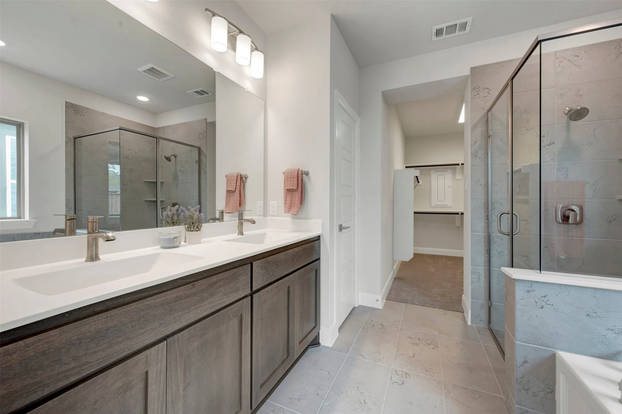 Dual vanity with white undermount sinks, bronze faucets, and dark wood-finish cabinetry