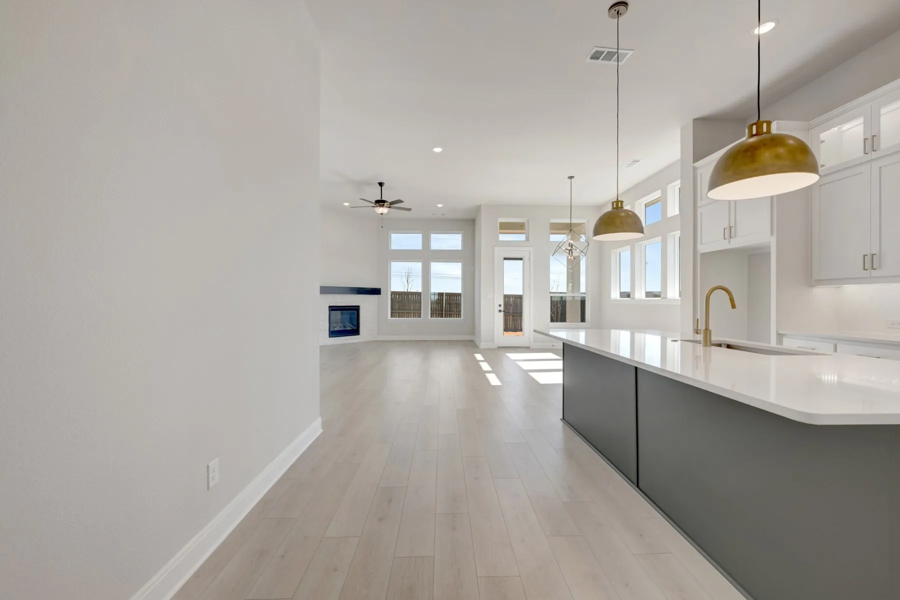 Kitchen, pendant lighting, two tone cabinetry, light wood-type flooring, and open floor plan