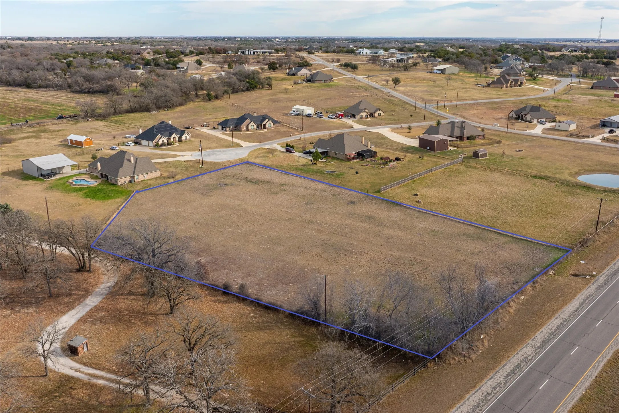 Aerial view of sparsely populated area featuring property parcel outlined