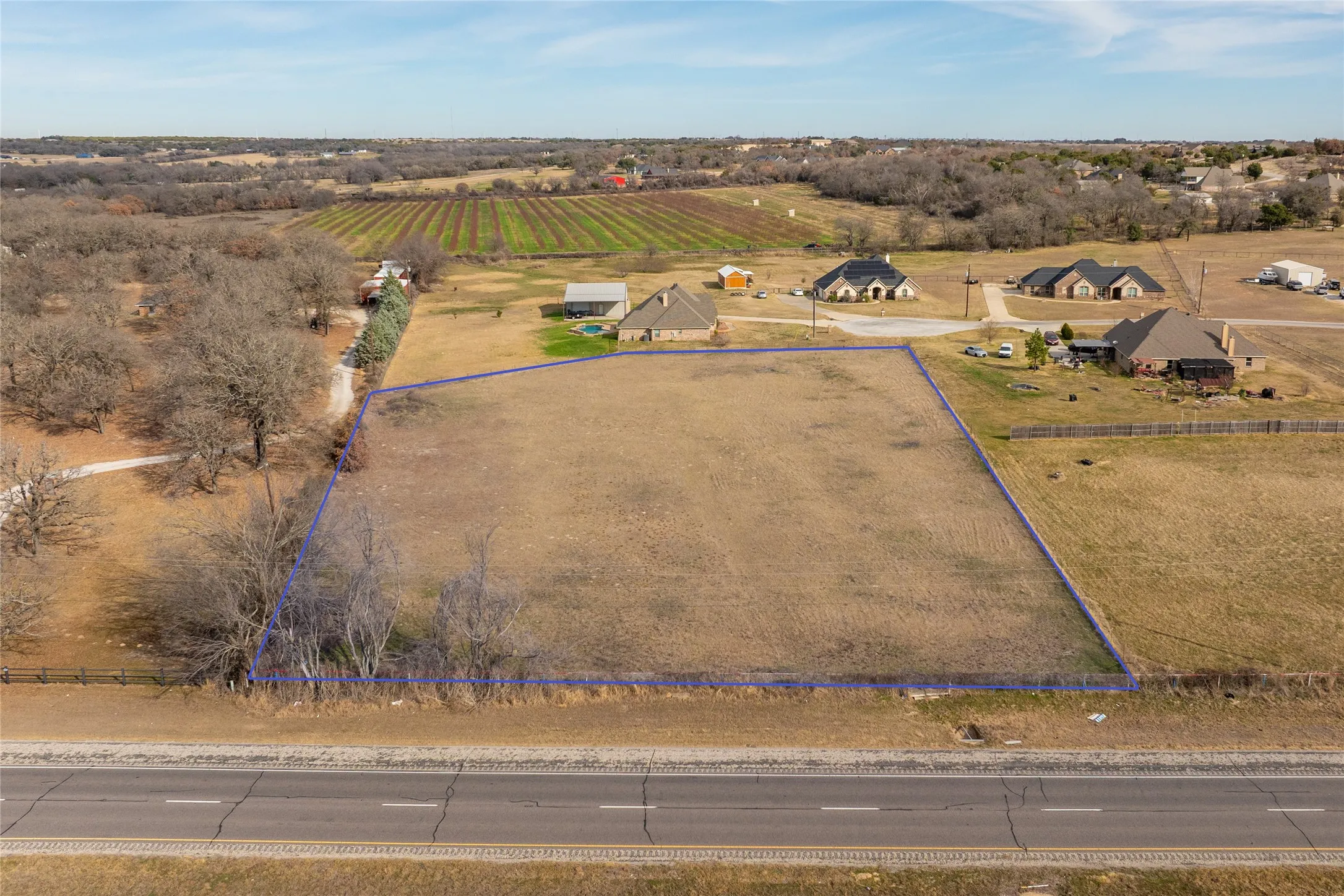 Aerial view of sparsely populated area with large plots for crops