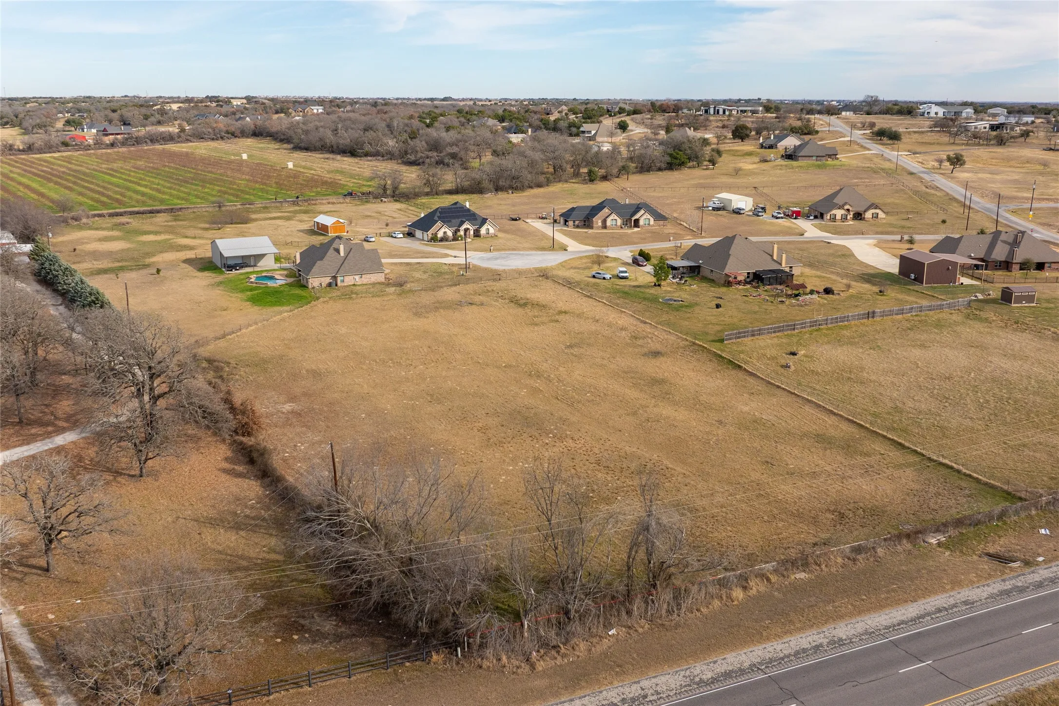 Aerial view of property and surrounding area featuring rural landscape and rows of crops