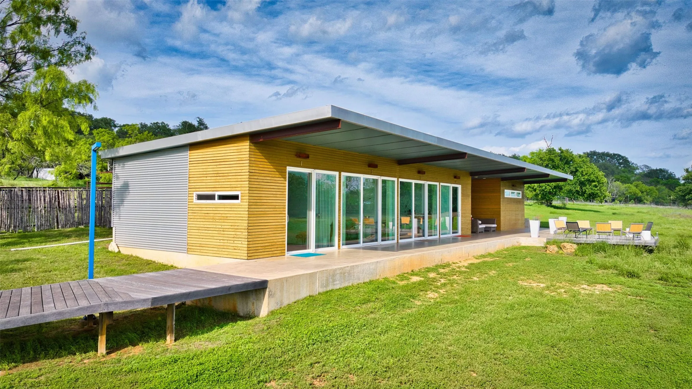 Contemporary exterior with a low-slope roofline, featuring horizontal wood siding and corrugated metal paneling