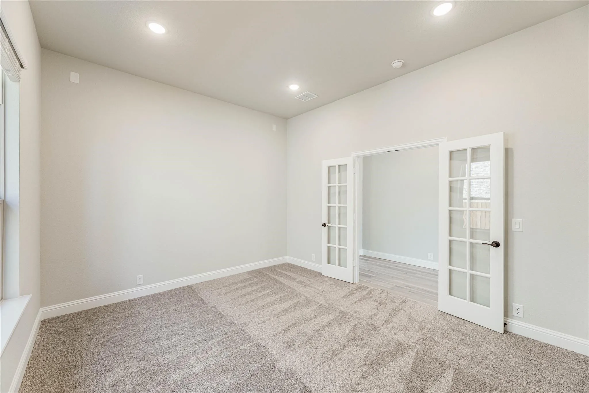Office without furniture. There is not carpet in the home now. This is only to give you an idea without furniture.  Builder photo