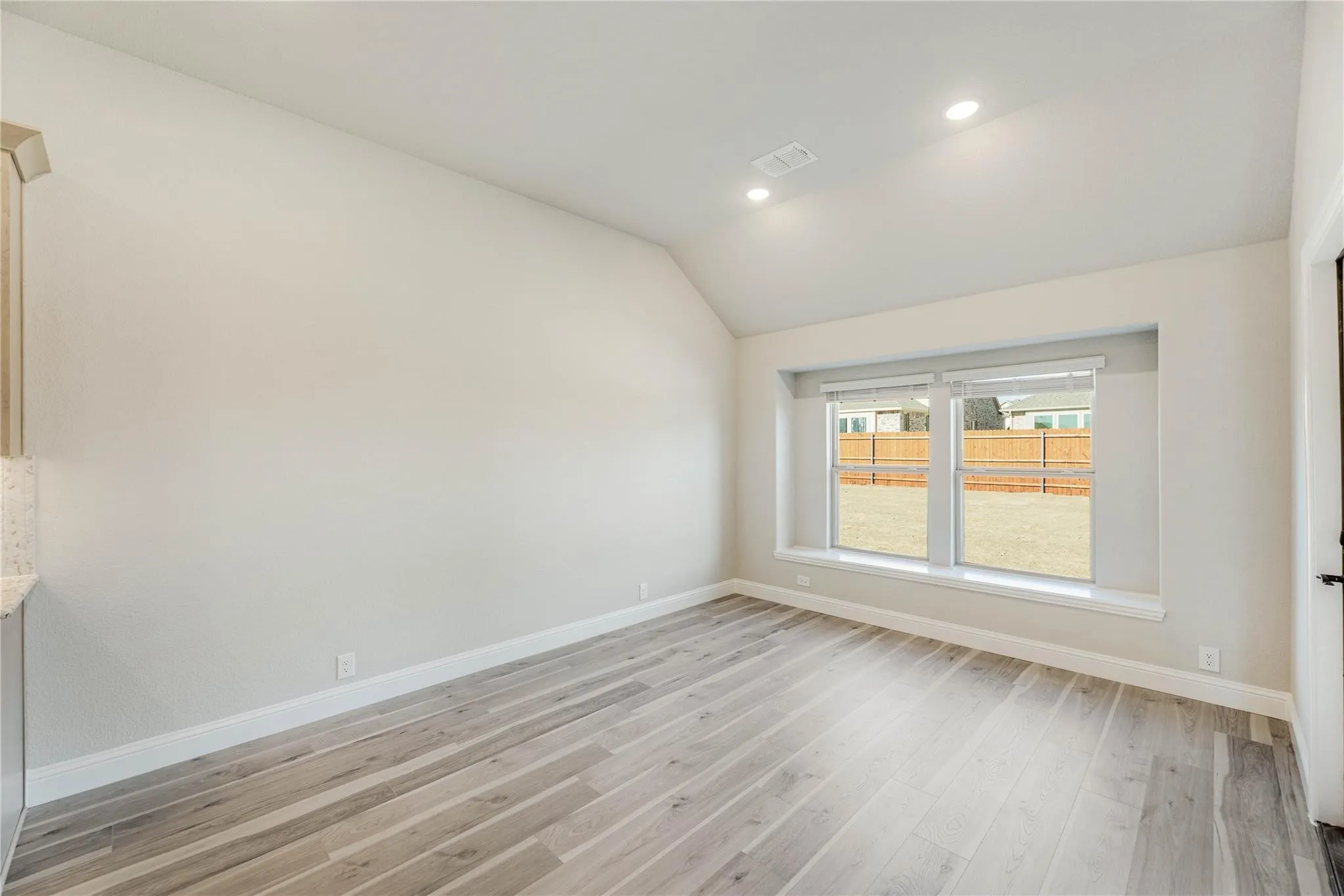 Builder photo.  View of the dining area towards the kitchen and family room.