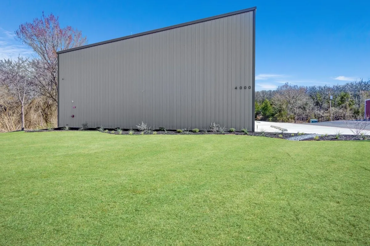 View of property exterior with a yard, a pole building, and an outdoor structure