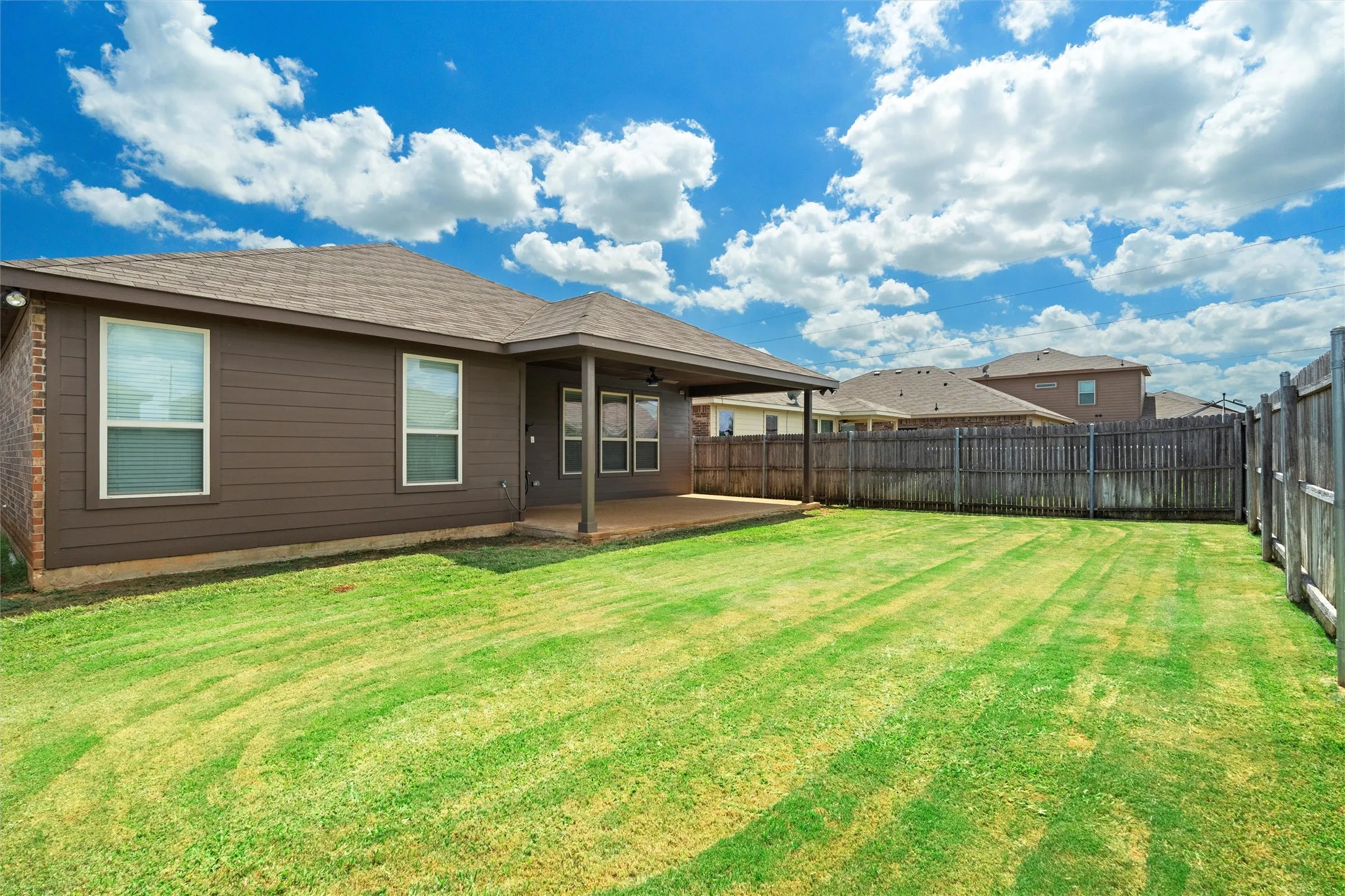 Back of property featuring a patio, ceiling fan, a fenced backyard, and roof with shingles