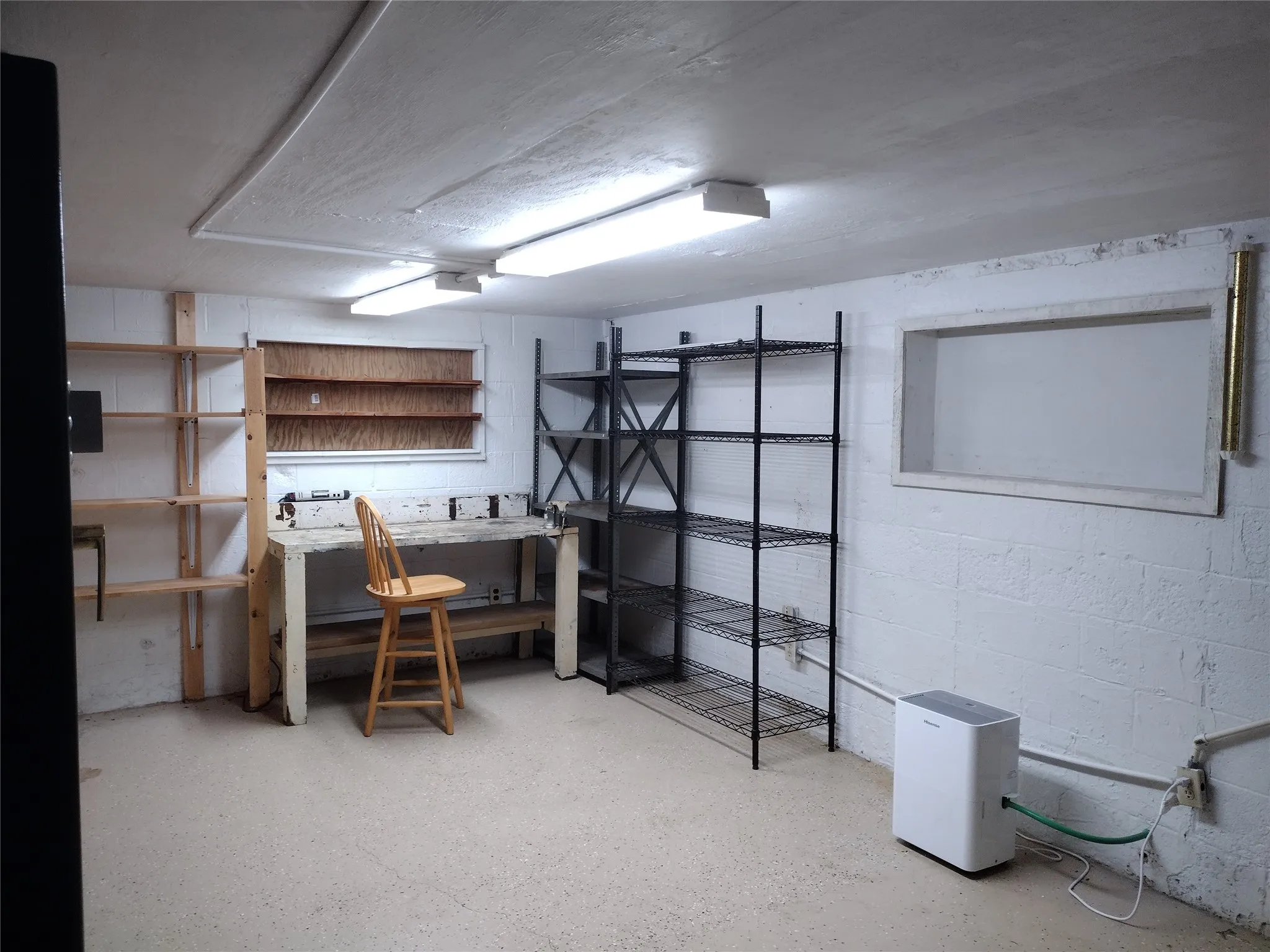 Finished below grade area with a workshop area and concrete block wall