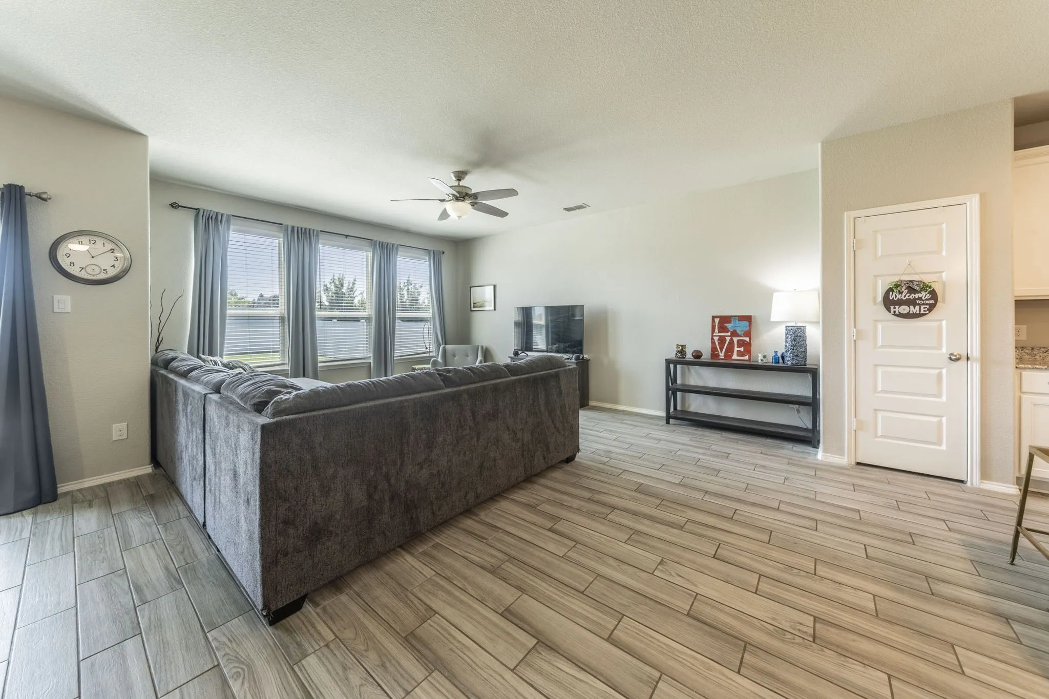 Living room featuring wood finish floors, a ceiling fan, and a textured ceiling