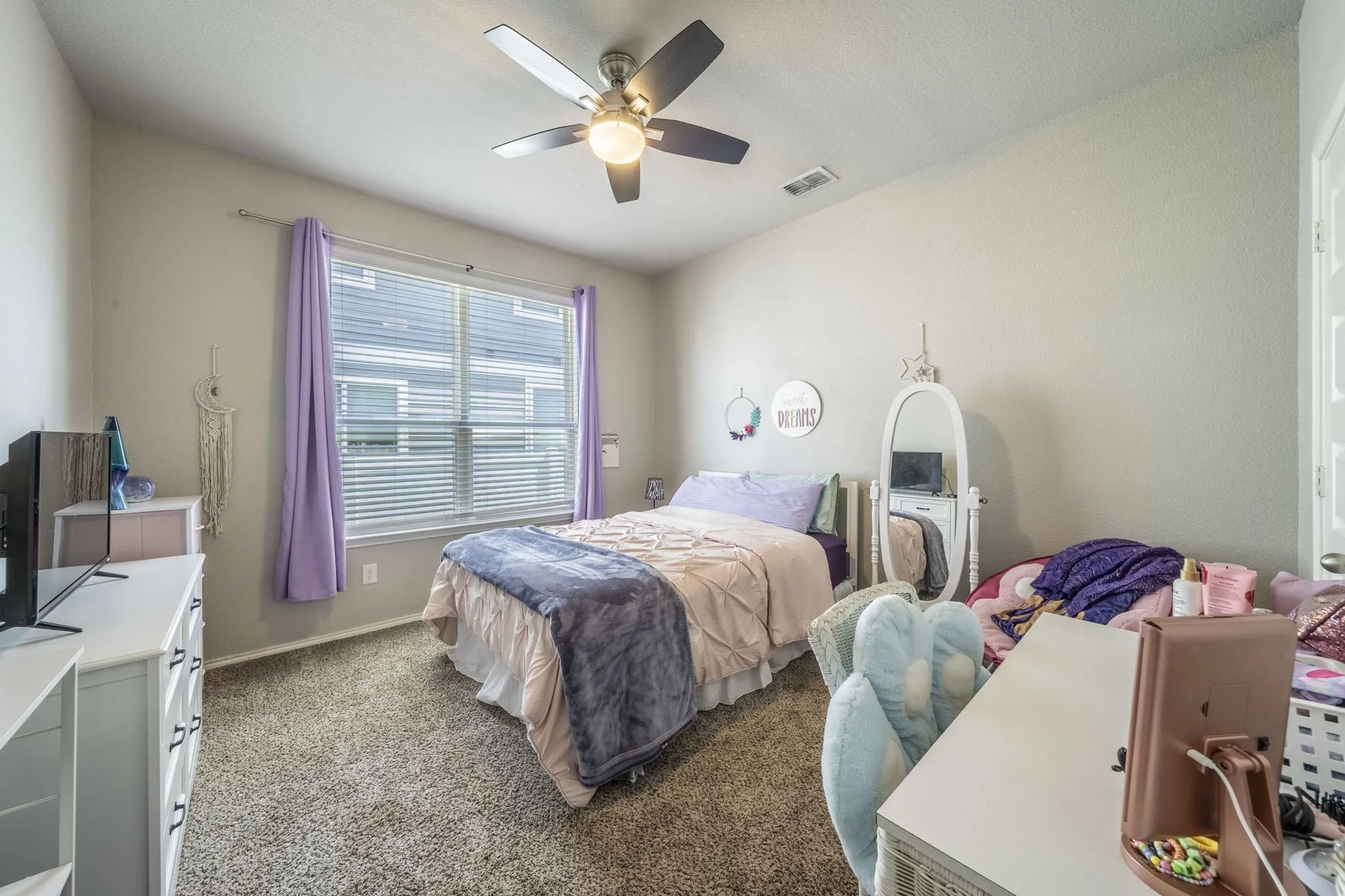 Carpeted bedroom featuring a ceiling fan and baseboards