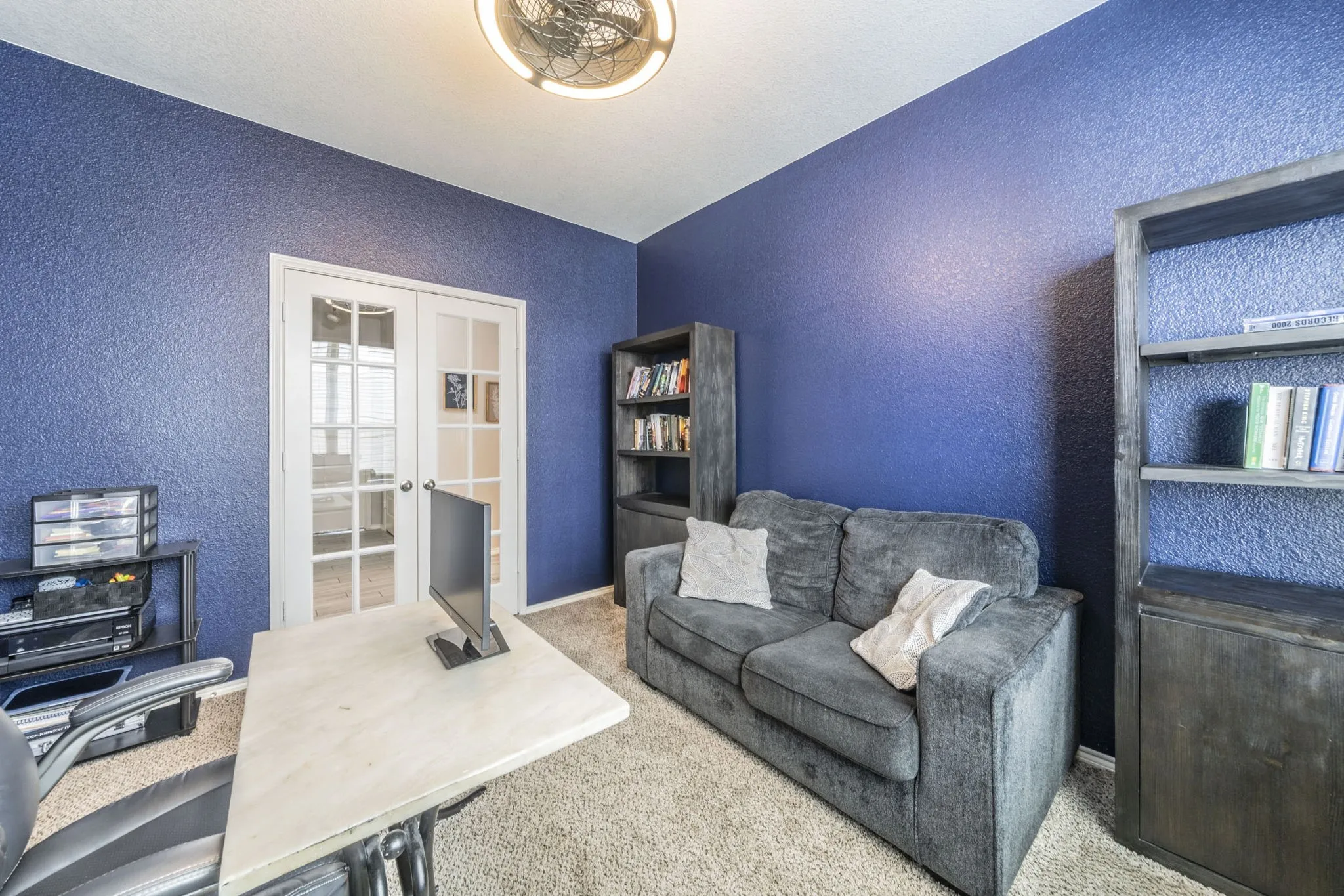 Home office with french doors, a textured wall, and carpet floors