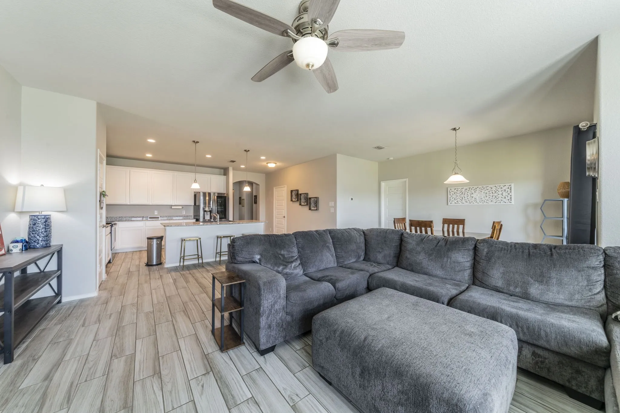 Living room featuring recessed lighting, ceiling fan, wood tiled floors, and arched walkways