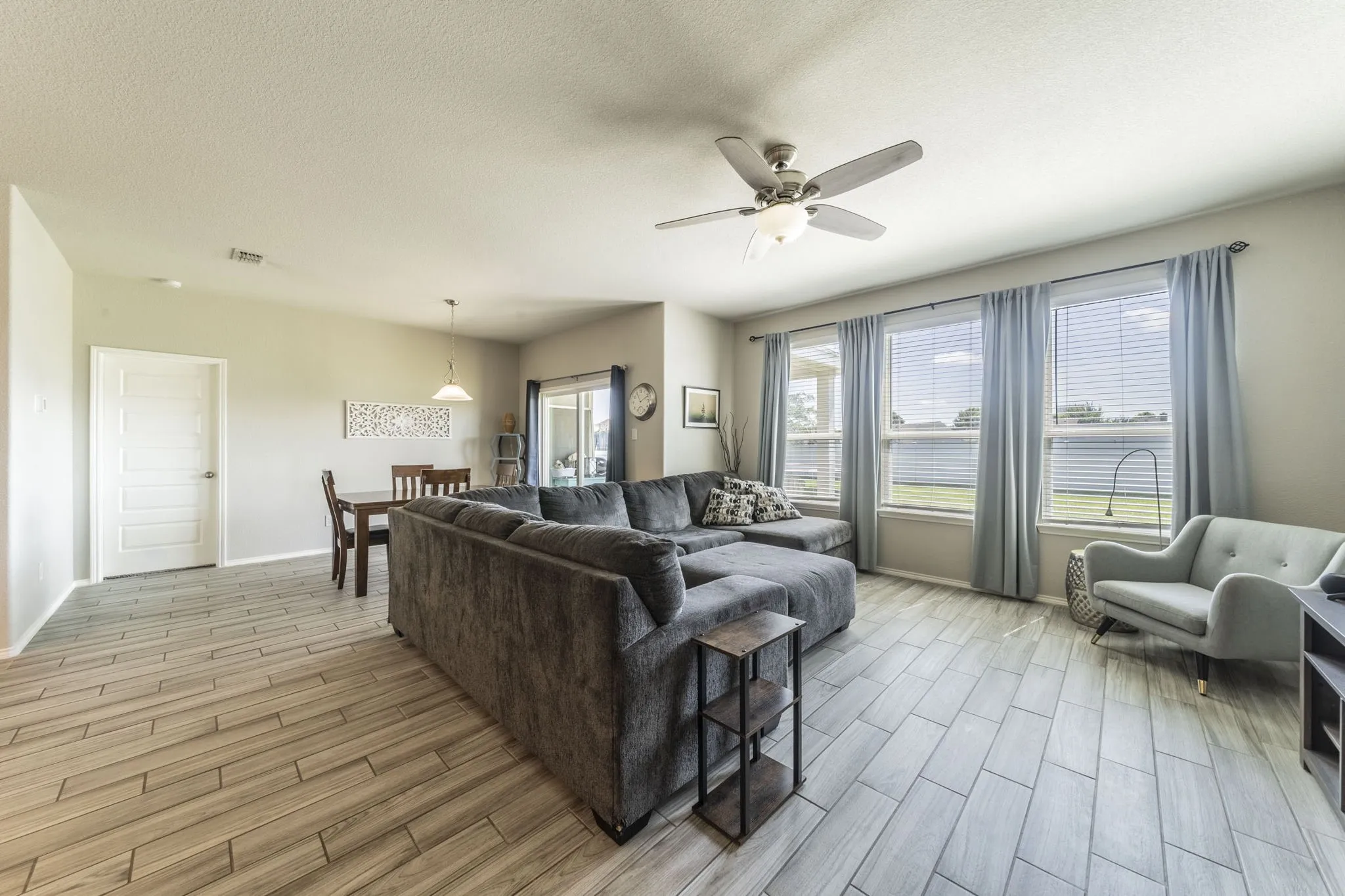 Living area featuring wood tiled floors, a textured ceiling, and a ceiling fan