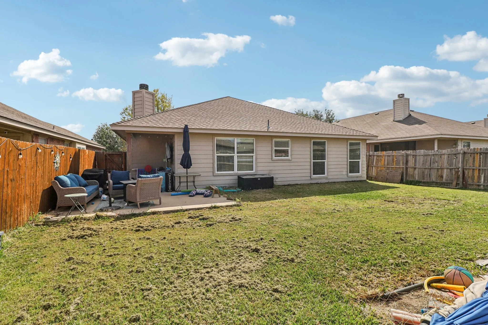 Rear view of property with a fenced backyard, a patio, a shingled roof, and outdoor lounge area