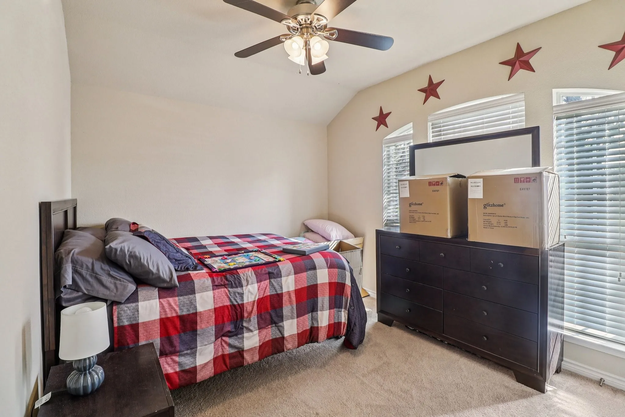 Bedroom with light colored carpet, lofted ceiling, and a ceiling fan