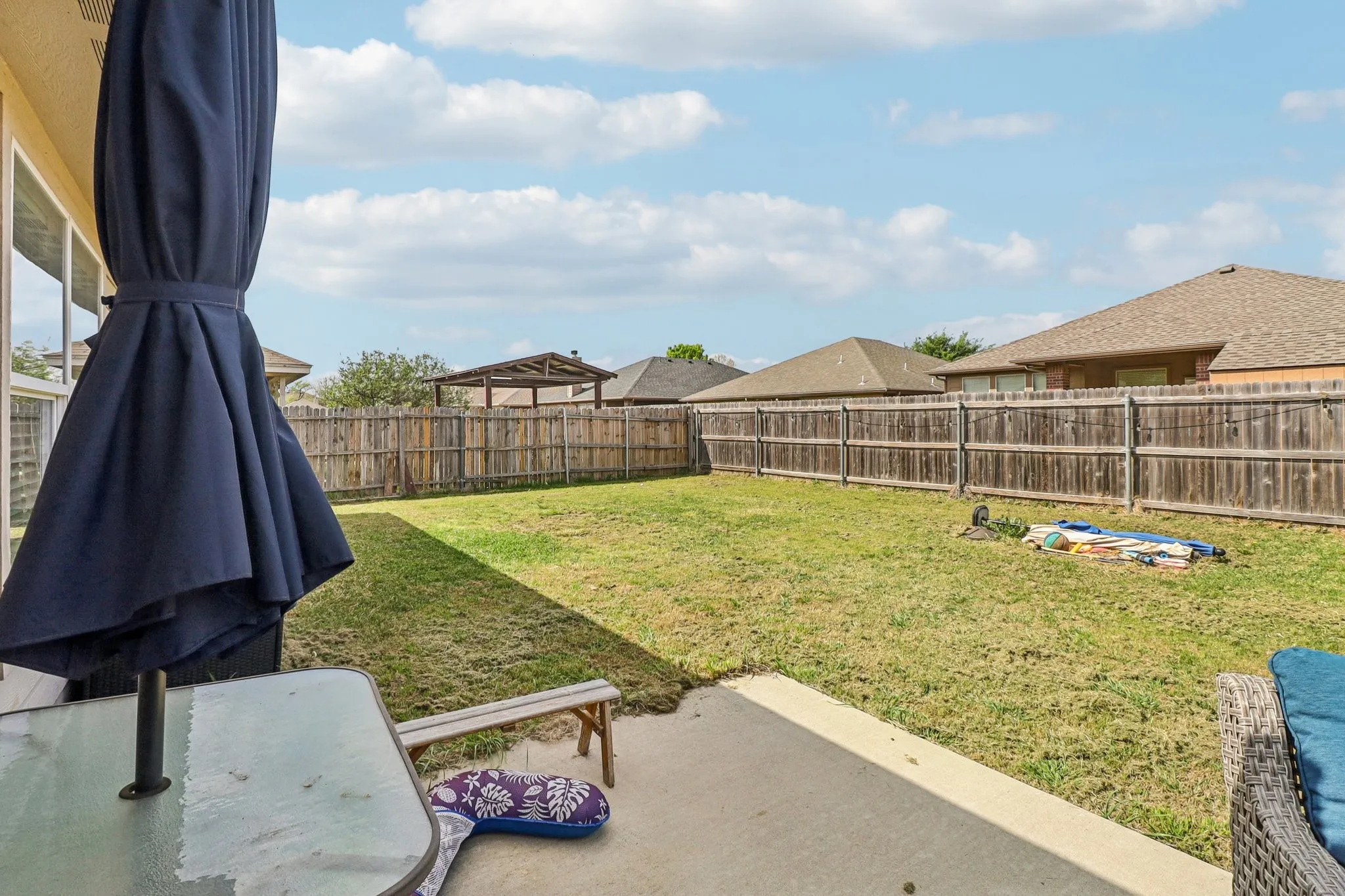 Fenced backyard with a patio