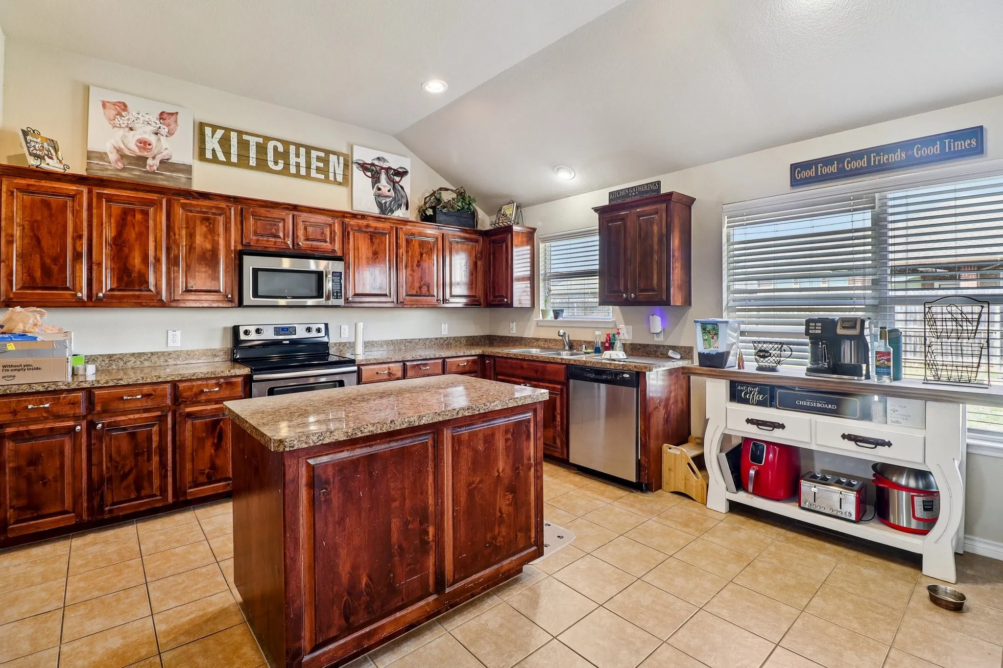Kitchen with stainless steel appliances, light tile patterned floors, lofted ceiling, a kitchen island, and recessed lighting