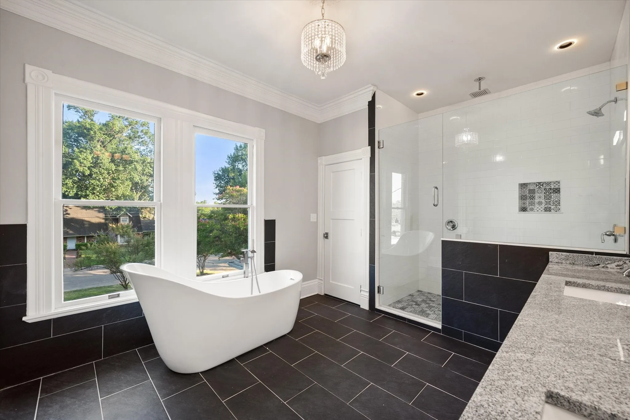 2nd floor primary self standing tub with a window with a view