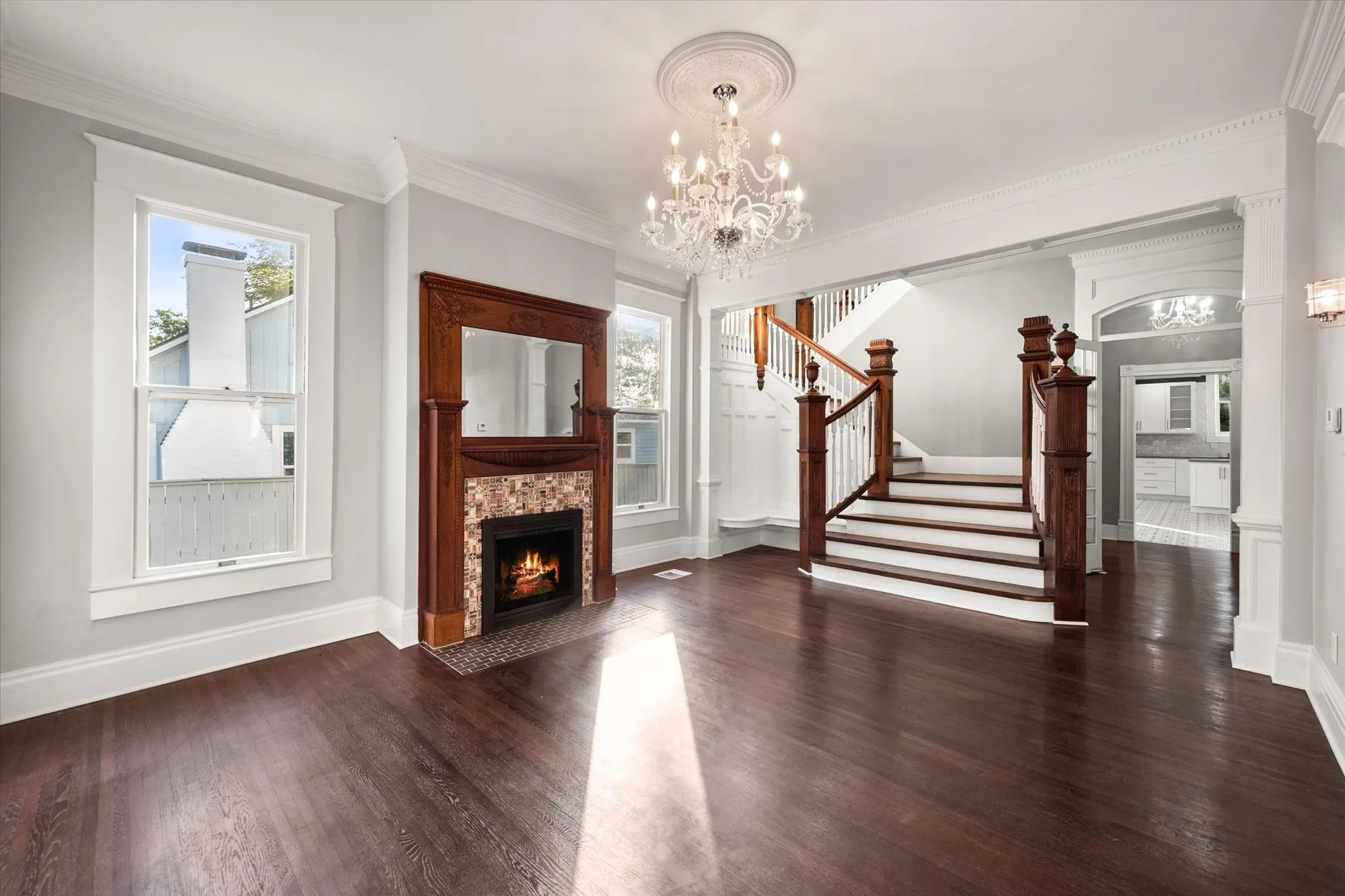 View from front door toward gas fireplace and elegant staircase