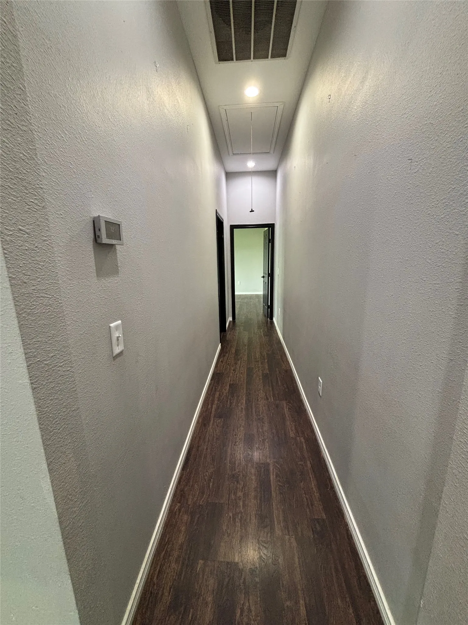 Hallway featuring dark wood-finish flooring, light gray walls, and recessed lighting