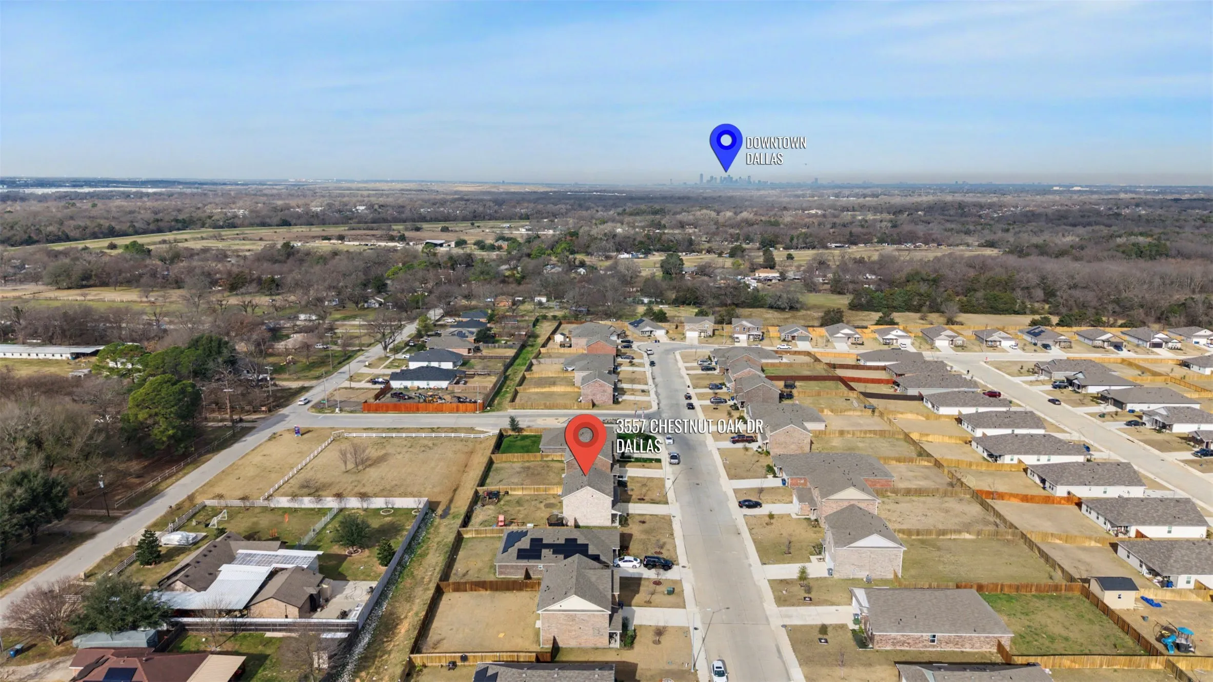 Aerial view of property and surrounding area featuring nearby suburban area