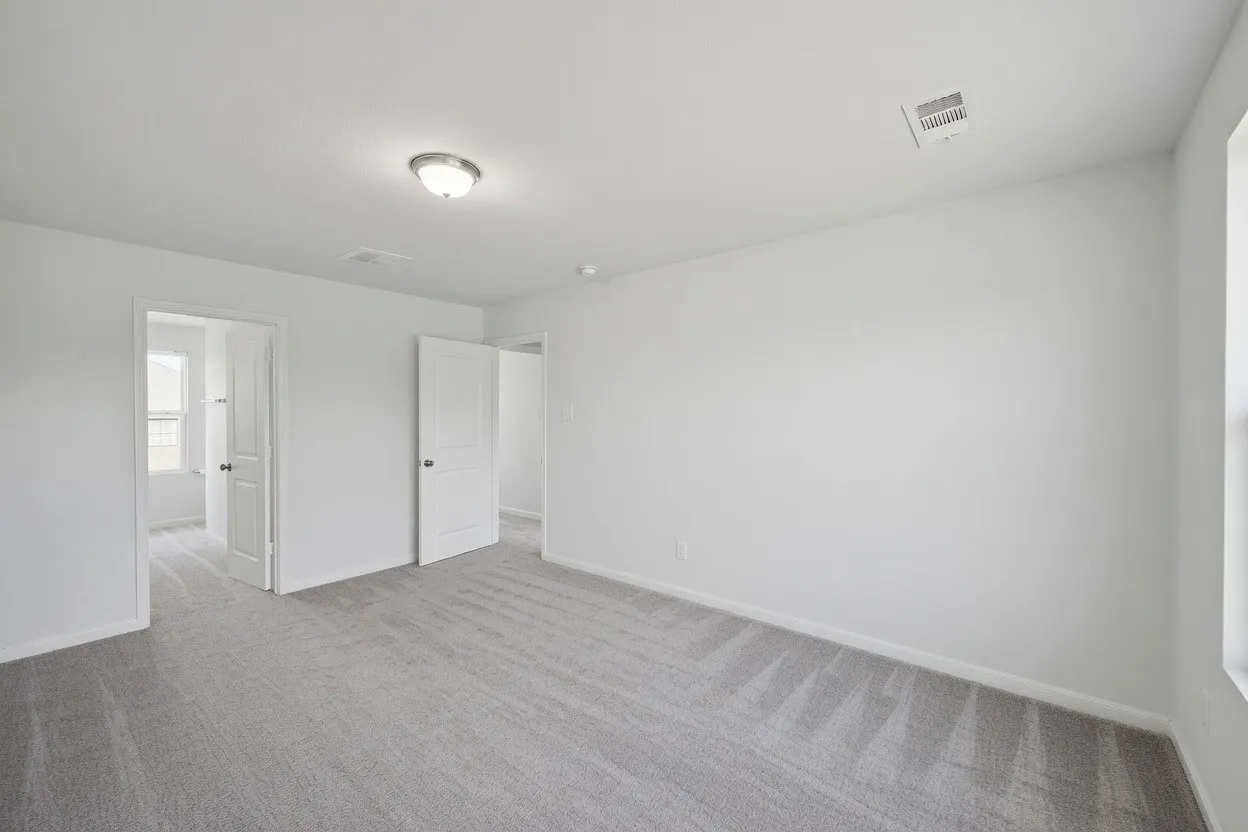 Light gray carpeting, light neutral wall color, overhead flush mount light fixture, white trim, and white interior doors