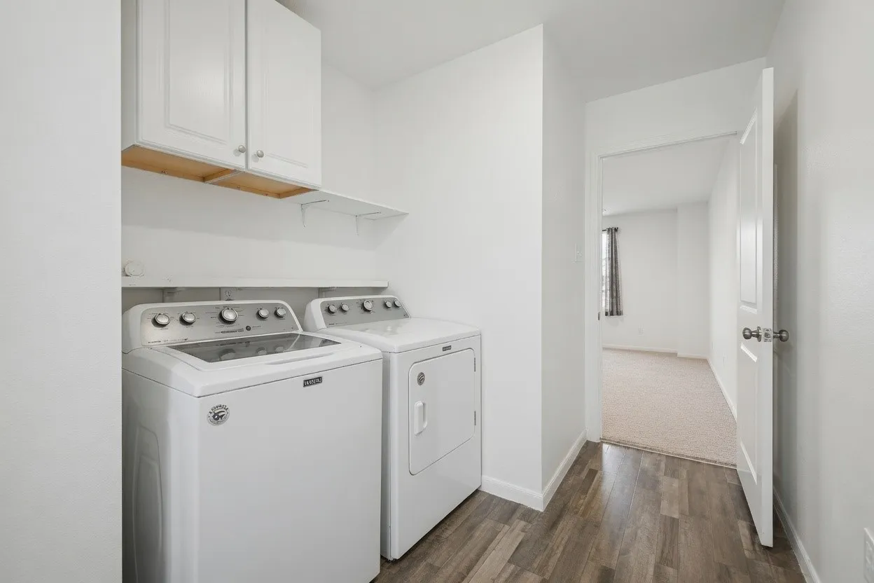 Laundry area featuring white cabinetry, open shelving, and wood-finish flooring