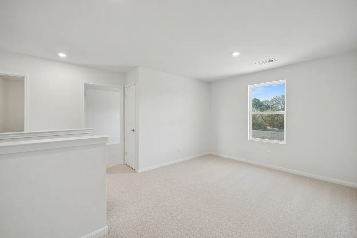 Wall-to-wall carpeting, recessed lighting, and a single pane window