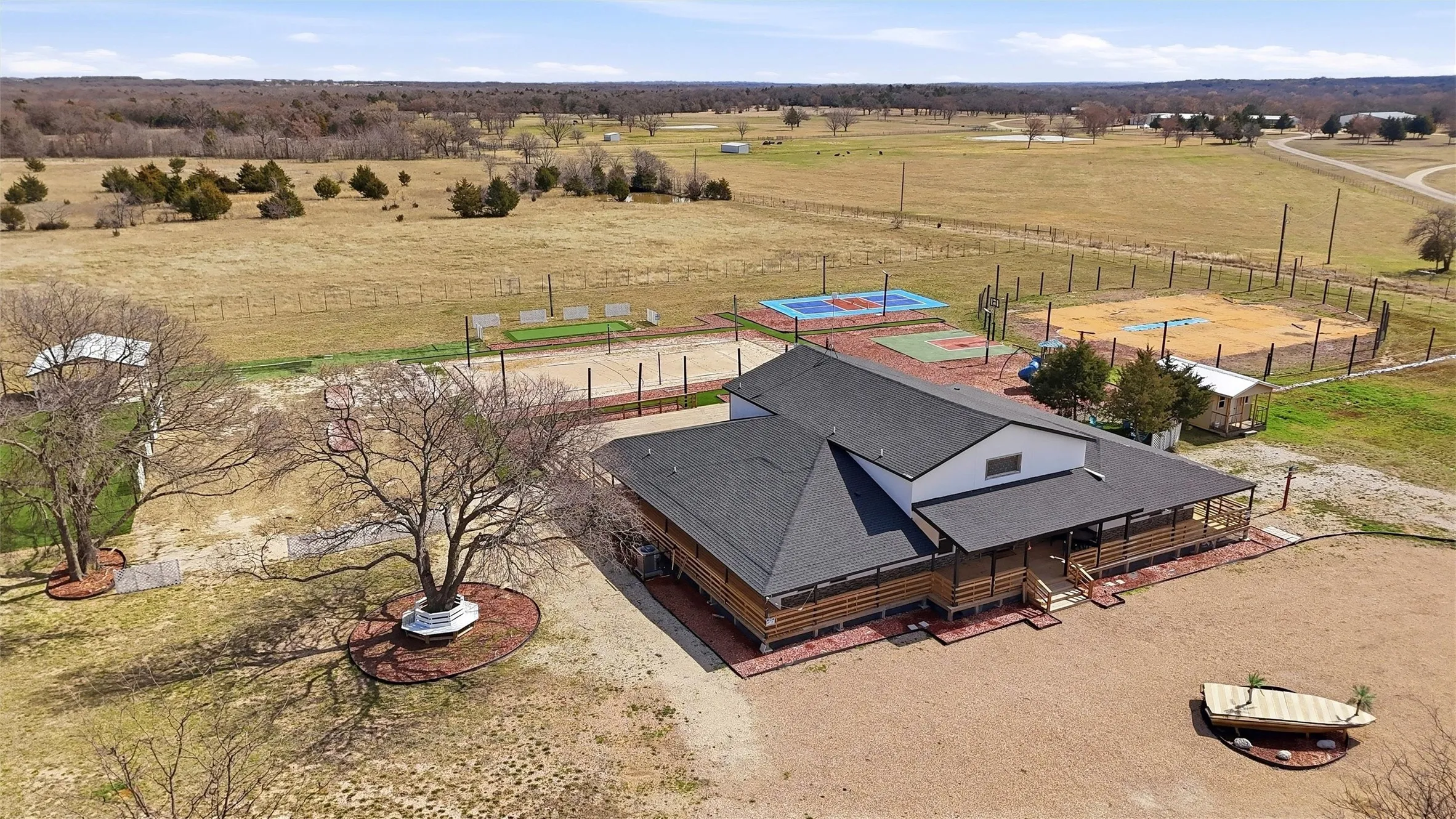 Aerial view showing sport courts and Ag property to the rear.