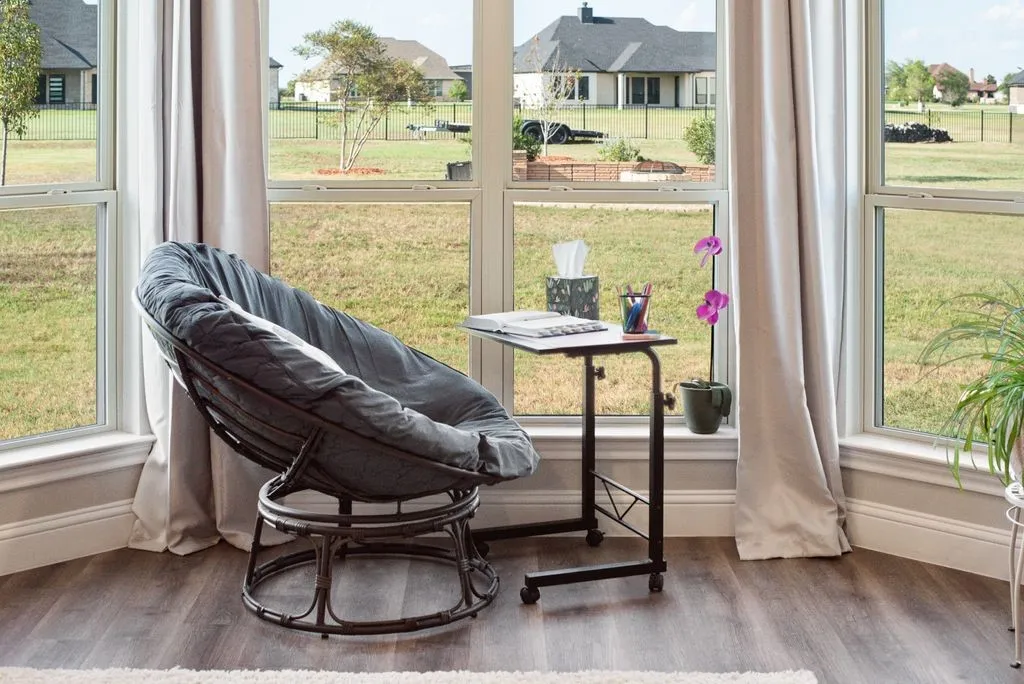 Bay window featuring multiple large windows, wood-finish flooring, and neutral wall tones