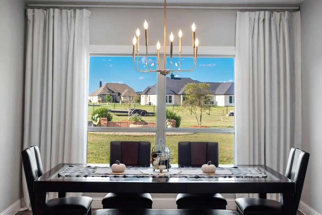 Large picture window with a chandelier, dark wood-finish flooring, and light-toned walls