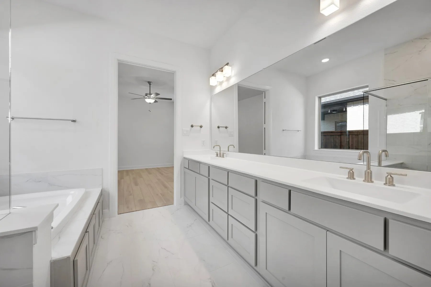 Full bathroom with double vanity, a garden tub, a marble finish shower, and light marble finish flooring