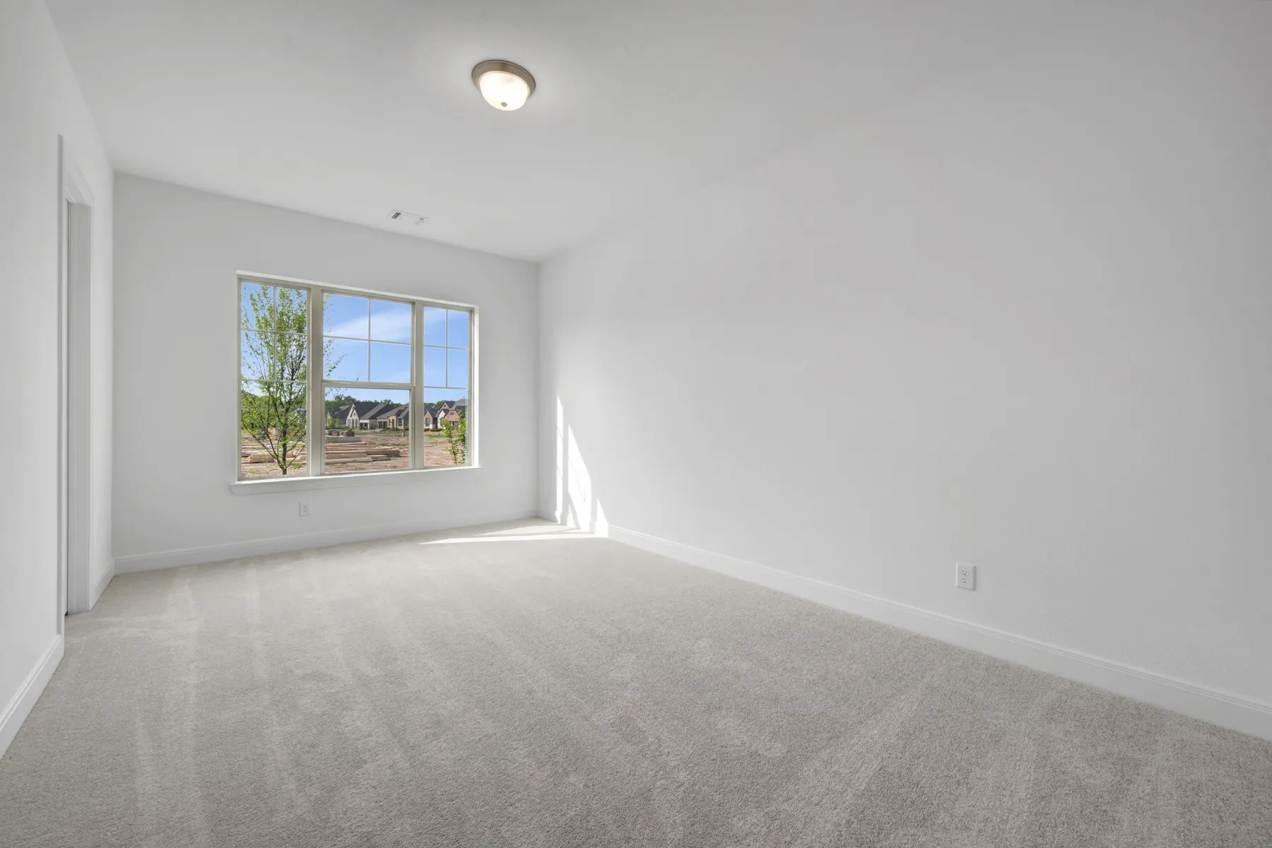 Spare room with light colored carpet and baseboards