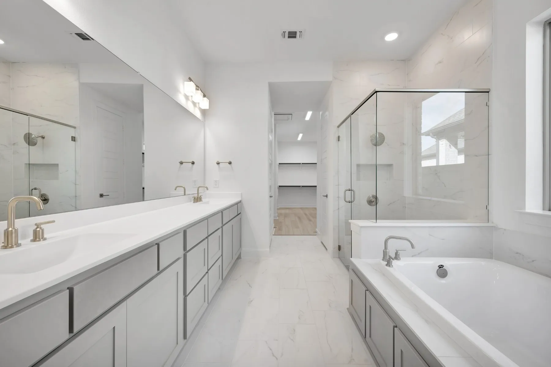 Full bathroom featuring a marble finish shower, double vanity, a garden tub, light marble finish floors, and recessed lighting