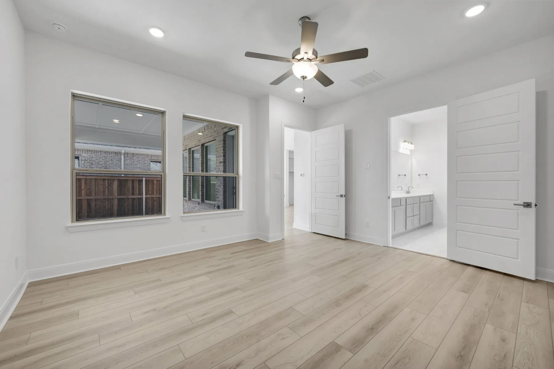 Unfurnished bedroom featuring a ceiling fan, recessed lighting, light wood finished floors, and ensuite bathroom
