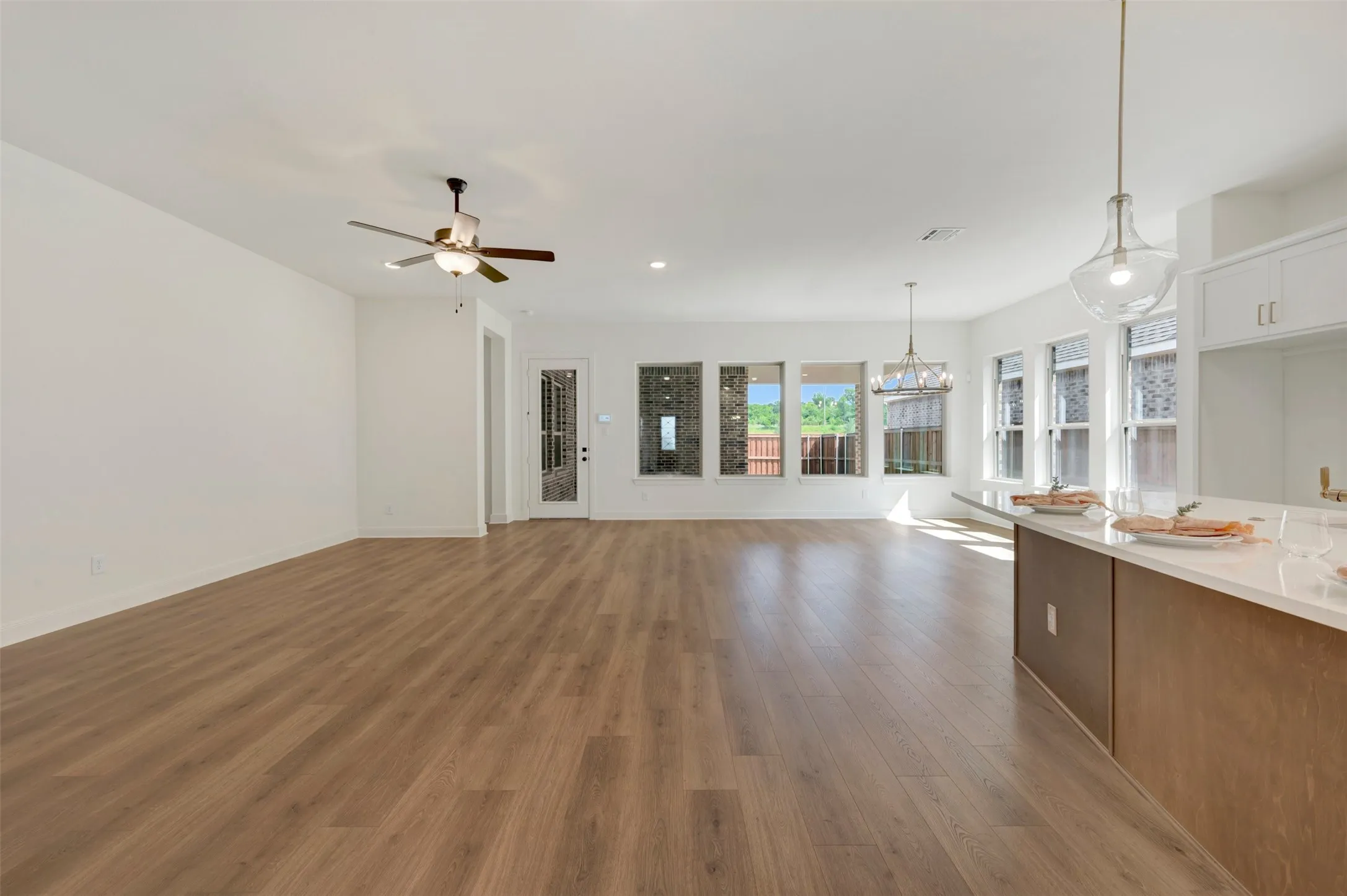 Expansive open-concept living space featuring wood-finish flooring, recessed lighting, and a ceiling fan