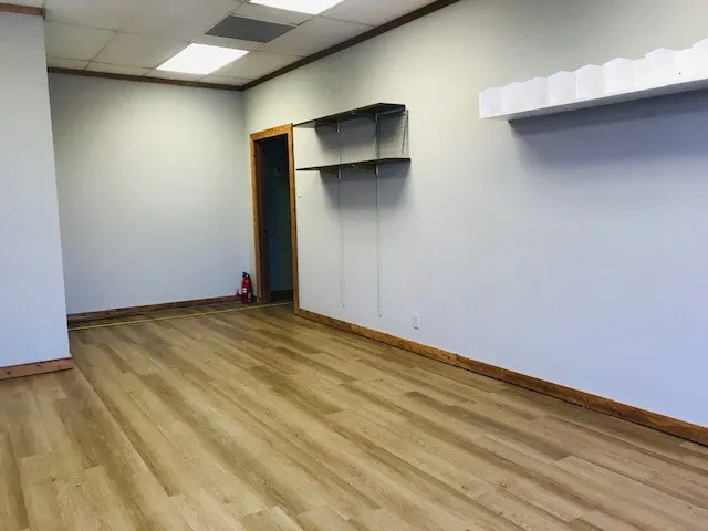 Spare room with a paneled ceiling and light hardwood / wood-style floors