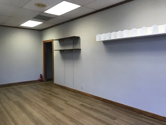 Unfurnished bedroom featuring a closet, hardwood / wood-style floors, and a drop ceiling