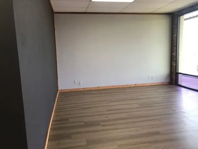 Unfurnished room featuring hardwood / wood-style floors and a drop ceiling