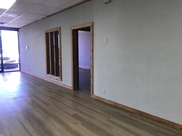 Unfurnished room with wood-type flooring and a drop ceiling