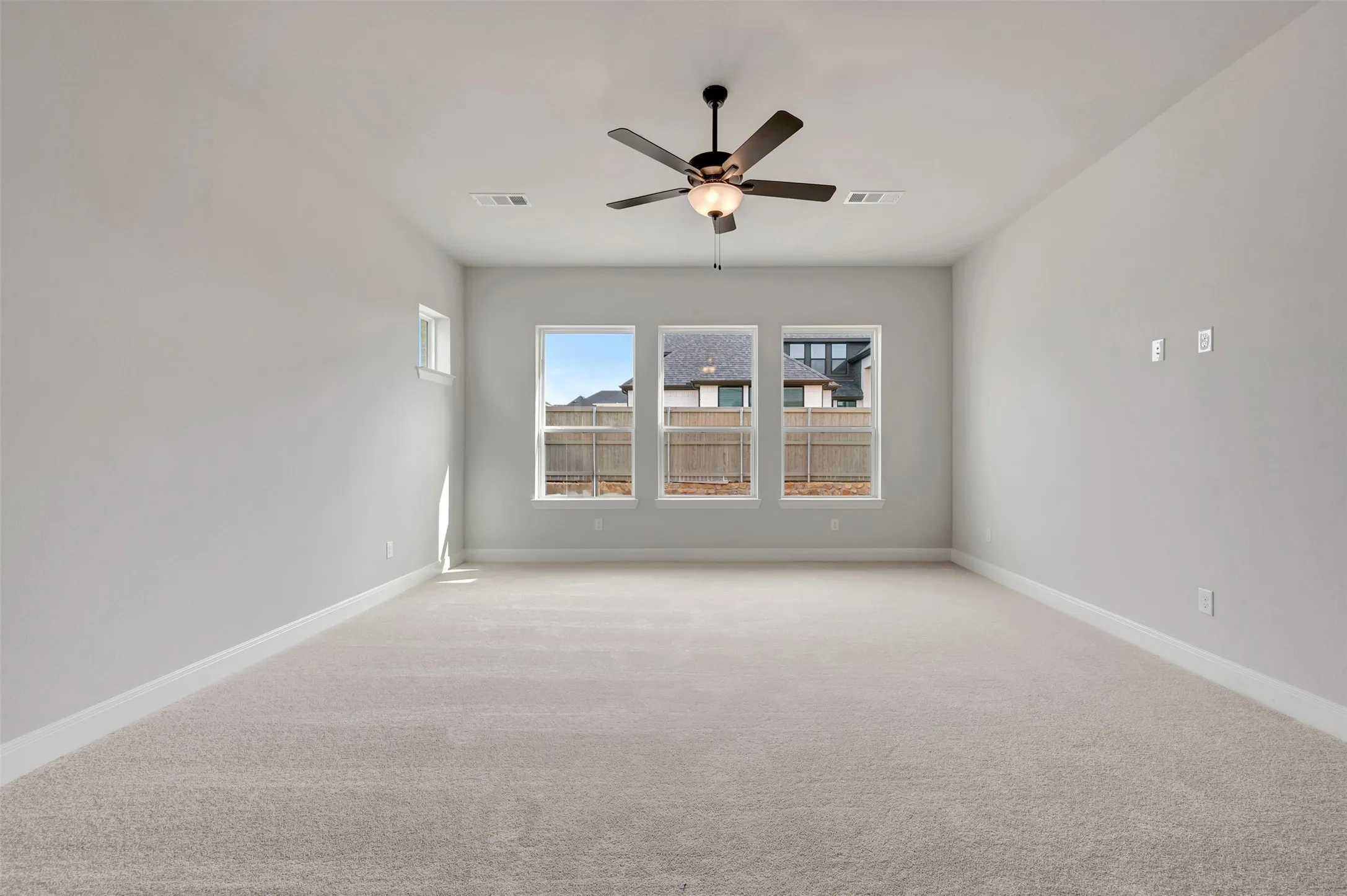 Unfurnished room featuring light carpet and a ceiling fan