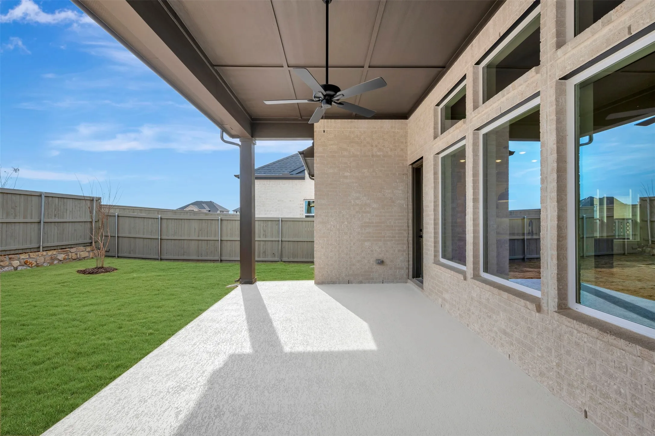 Fenced backyard featuring ceiling fan and a patio area