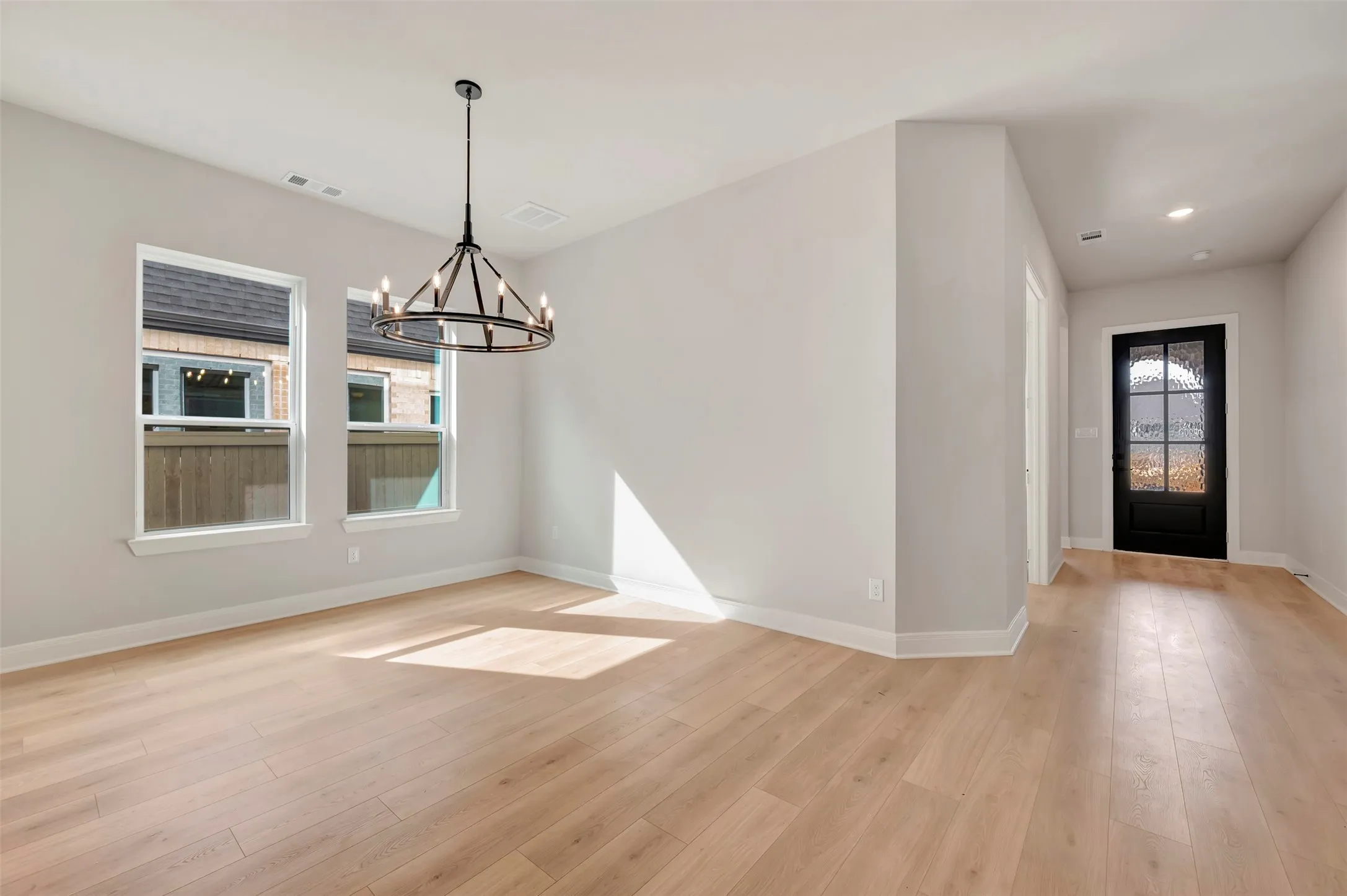 Unfurnished dining area featuring hanging lights and light wood-type flooring