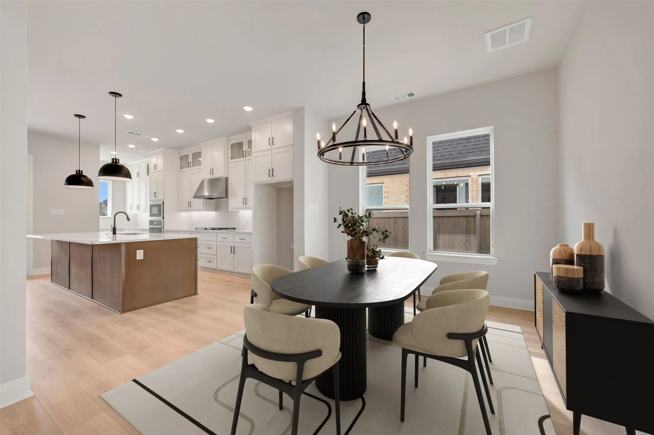 Dining space with light wood-type flooring and suspended lighting